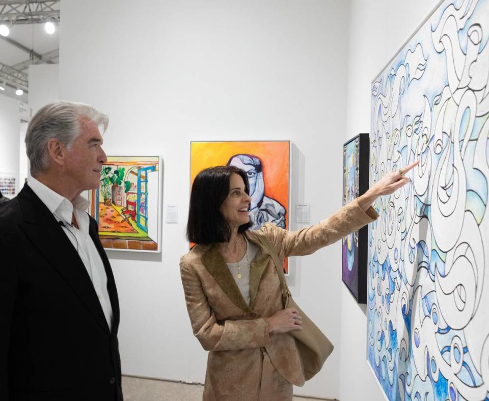Actor / artist Pierce Brosnon discusses his art with a fairgoer at Art Miami.
