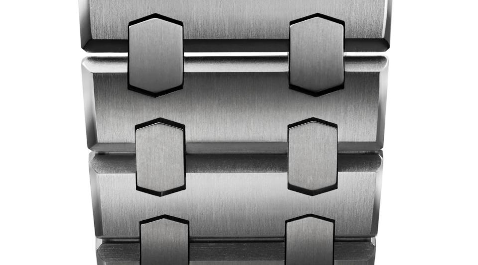 一體式整合鍊帶採鈦金屬材質製成，兩個六角形中節的設計，讓鍊帶細節層次更豐富。