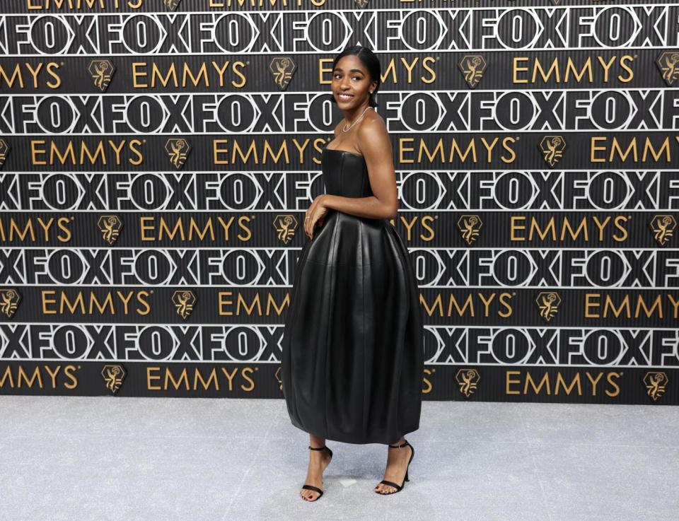 Ayo Edebiri wears a black dress on the Emmys red carpet.