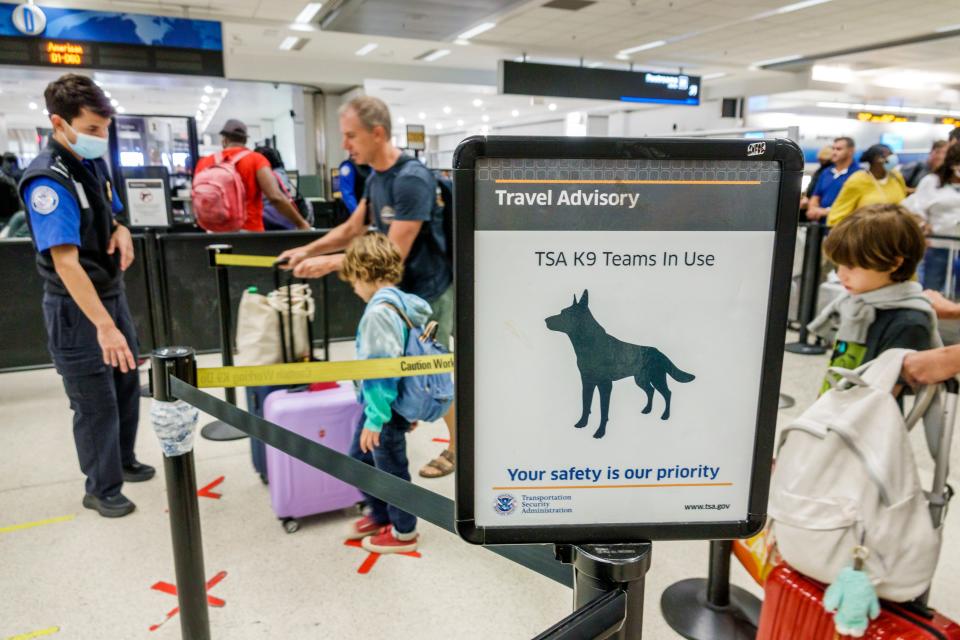 A sign advising the use of TSA K9 bomb-sniffing dogs at Miami International Airport.