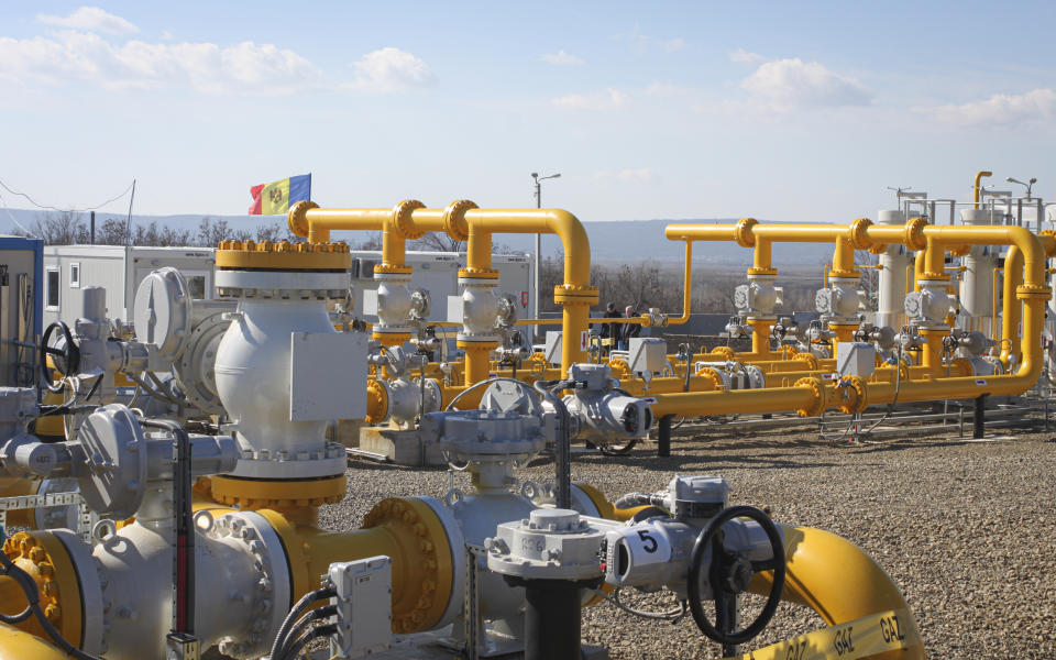 Men walk next to pipelines of the national natural gas distribution network outside Ungheni, Moldova, March 4, 2015. The country faces a looming natural gas supply shortage this winter after it failed to renew a long-term contract with Russia, as on Tuesday, Oct. 26, 2021, the former Soviet republic received a million cubic meters of gas from Poland, the first time in history it has turned to a non-Russian supplier, amid increasing geopolitical tensions as Moldova looks to forge closer ties with the European Union after for years being under strong Russian influence.(AP Photo/Aurel Obreja)