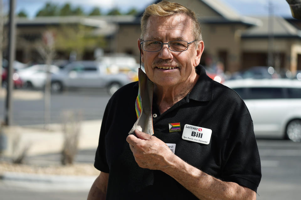 In this Wednesday, May 19, 2021, photograph, Bill Easton, a checker at a Safeway grocery store, is shown in the shopping center in which the store is located in Aurora, Colo. Easton, like many other workers in retail sales jobs, is fully vaccinated but is concerned about risks posed as retailers change their mask-wearing policies for customers. (AP Photo/David Zalubowski)