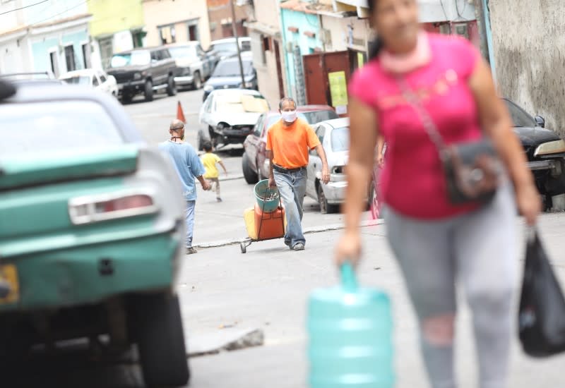 An elder pulls a cart with plastic container filled with water through a hill in the low-income neighbourhood of Artigas amid the coronavirus disease (COVID-19) outbreak in Caracas