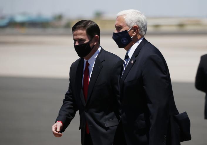 Vice President Mike Pence, right, walks with Arizona Gov. Doug Ducey, left, as the two head to a meeting to discuss the surge in coronavirus cases July 1, 2020, in Phoenix. As the public face of the administration's coronavirus response. Pence has been trying to convince Americans that the country is winning even as cases spike in large parts of the country. For public health experts, that sense of optimism is detached from reality. (AP Photo/Ross D. Franklin)