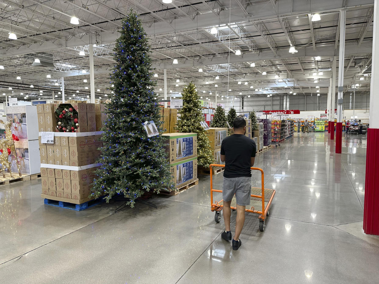 A shopper passes by a display of Christmas trees in a Costco warehouse Thursday, Aug. 24, 2023, in Sheridan, Colo. (AP Photo/David Zalubowski)