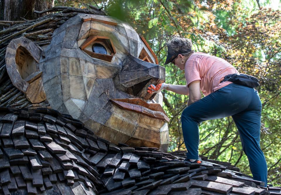 Jenny Zeller, Arts and Nature Curator at Bernheim Forest, cleaned the face of giant troll Mama Loumari as part of an annual cleaning and repair of the wooden sculptures. July 20, 2022