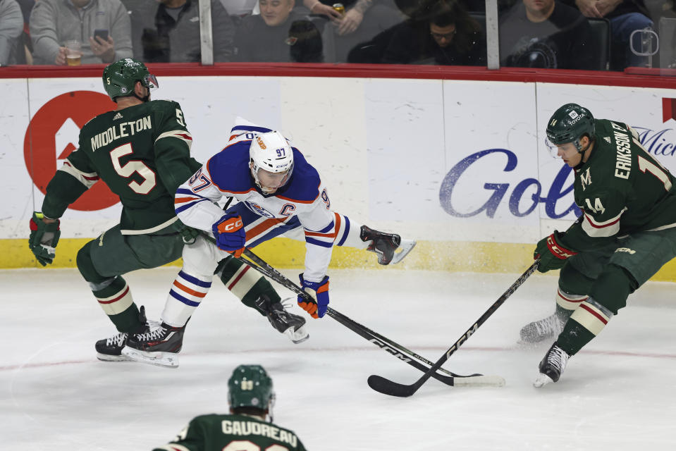 Edmonton Oilers center Connor McDavid (97) goes after the puck against Minnesota Wild center Joel Eriksson Ek (14) during the first period of an NHL hockey game Thursday, Dec. 1, 2022, in St. Paul, Minn. (AP Photo/Stacy Bengs)