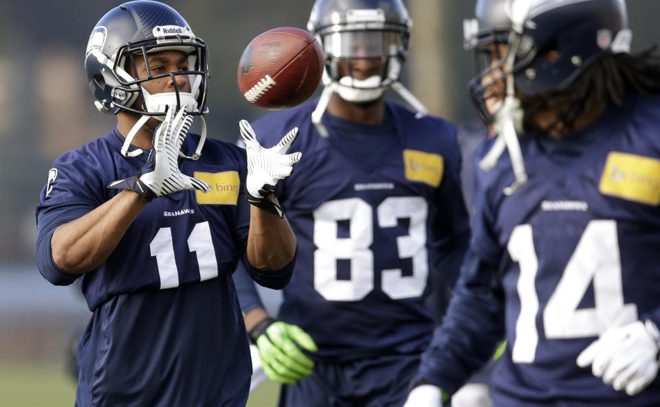 Seattle Seahawks wide receiver Percy Harvin (11) catches a ball tossed to him during warmups for NFL football practice, Friday, Jan. 3, 2014, in Renton, Wash. Looking on arewide receiver Ricardo Lockette (83) and practice squad wide receiver Arceto Clark (14). (Seattle plays at home in a playoff game on Jan. 11. AP Photo/Ted S. Warren)