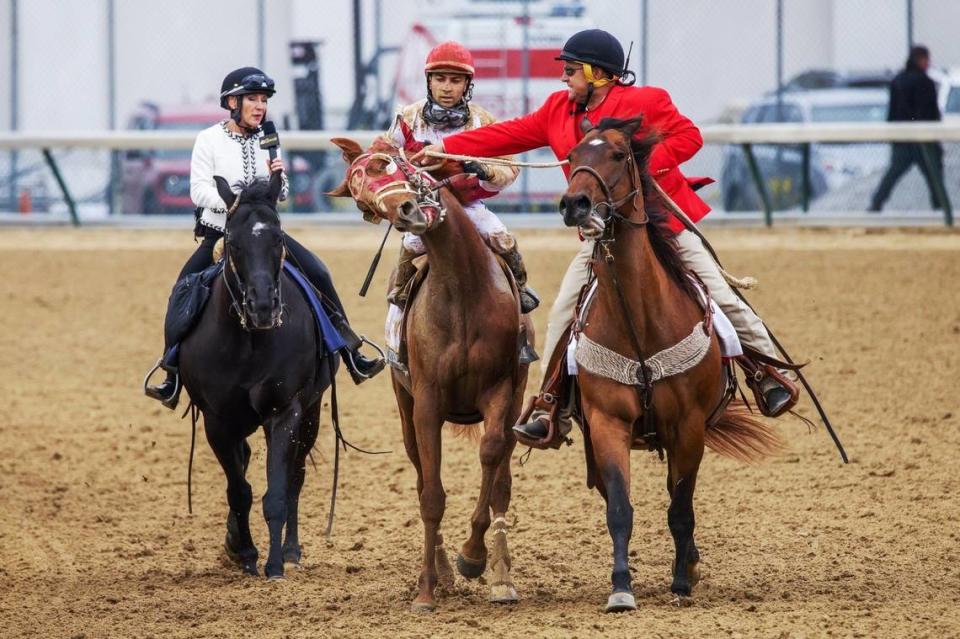 Outrider Greg Blasi, right, struggled to get an excited Rich Strike under control after the horse nipped at the leg of him and his track pony as they guided the horse to the winners circle at Churchill Downs in Louisville, Ky., Saturday May 7, 2022, after Rich Strike won the 148th Kentucky Derby. At left is NBC’s Donna Barton Brothers waiting to interview winning jockey Sonny Leon.