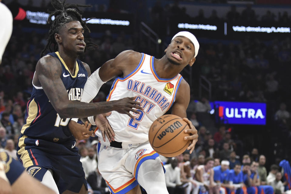 Oklahoma City Thunder guard Shai Gilgeous-Alexander, right, pushes past New Orleans Pelicans guard Kira Lewis Jr, left, in the first half of an NBA basketball game, Wednesday, Nov. 1, 2023, in Oklahoma City. (AP Photo/Kyle Phillips)
