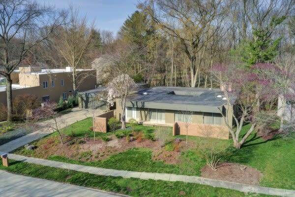 A concrete driveway leads to the two-car garage which also houses the private guest wing.