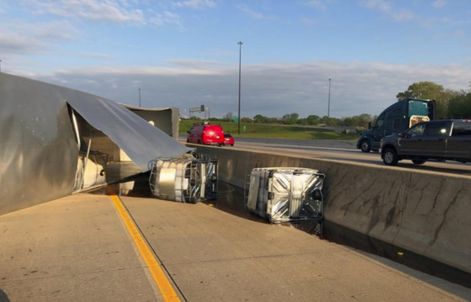 This photo released by the Indiana State Police shows a semi-trailer hauling honey overturned on a northwestern Indiana highway, spilling some of the sticky substance and restricting travel for hours in Hammond, Ind., Wednesday, May 15, 2019. State police say the truck was hauling about 41,000 pounds of amber honey along Interstate 80/94 when the driver lost control and the truck overturned. At least four containers of honey were leaking and mixing with diesel fuel from the overturned vehicle. (Indiana State Police via AP)