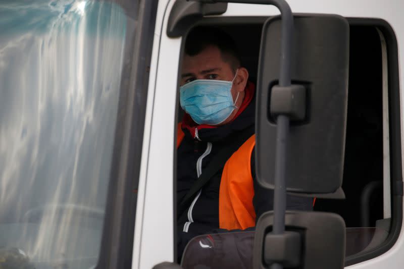 FILE PHOTO: A truck driver wearing a protective face mask arrives at the Amazon logistics center in Lauwin-Planque