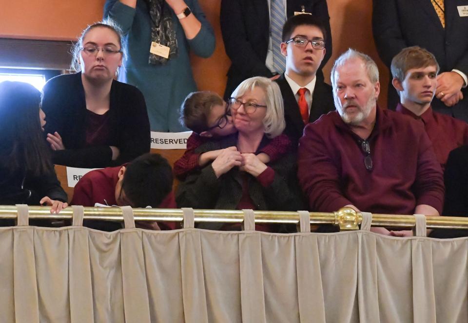 Peggy Anderson, foster and adoptive mom, receives a kiss on the cheek from her son after she and her husband, Rodney, were honored by Governor Kristi Noem during her State of the State address on Tuesday, January 11, 2022, at the South Dakota State Capitol in Pierre.