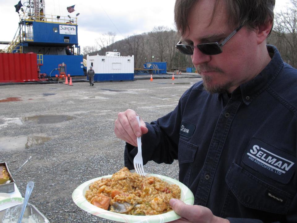 In this Monday, April 1, 2013 photo, Geologist Steve Clark prepares to take a bite of jambalaya prepared for workers on a natural gas drilling site near Montoursville, Pa. An influx of workers from the South to fill gas drilling jobs has led area caterers, restaurants and grocery stores to serve more Southern cuisine like jambalaya and boudin. (AP Photo/Genaro C. Armas)