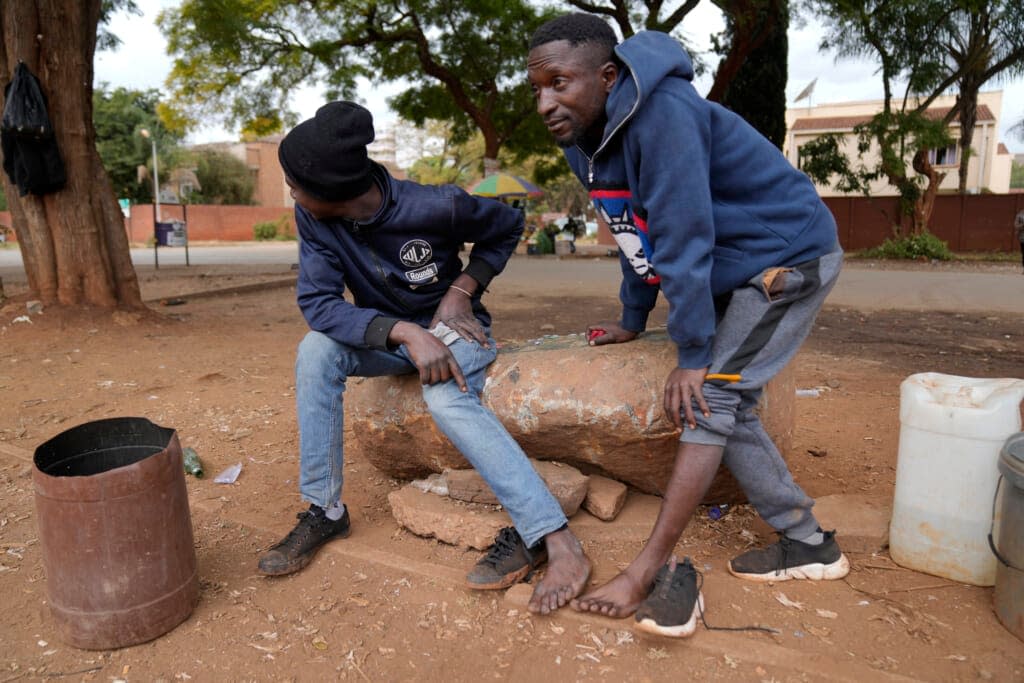 Street vendors take off their shoes to show their toes on the streets of Harare, Zimbabwe, Thursday, June, 9, 2022.(AP Photo/Tsvangirayi Mukwazhi)