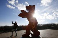 A woman stands beside the logo for the upcoming 66th Berlinale International Film Festival in Berlin, Germany, February 10, 2016. REUTERS/Fabrizio Bensch