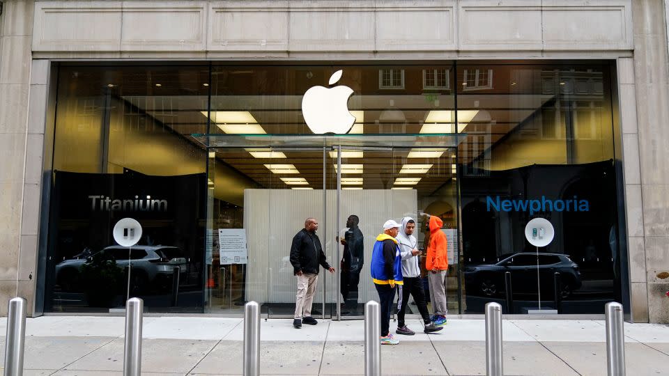 People outside an Apple store on Wednesday after the business was ransacked the previous evening. - Matt Rourke/AP