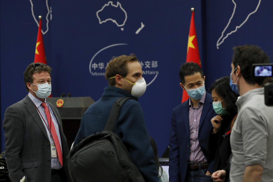 The New York Times Beijing based correspondent Steven Lee Myers, left, chats with other foreign journalists after attending a daily briefing by Chinese Foreign Ministry spokesman Geng Shuang at the Ministry of Foreign Affairs office in Beijing, Wednesday, March 18, 2020. At least 13 American journalists stand to be expelled from China in retaliation for a new limit imposed by the Trump administration on visas for Chinese state-owned media operating in the U.S. (AP Photo/Andy Wong)