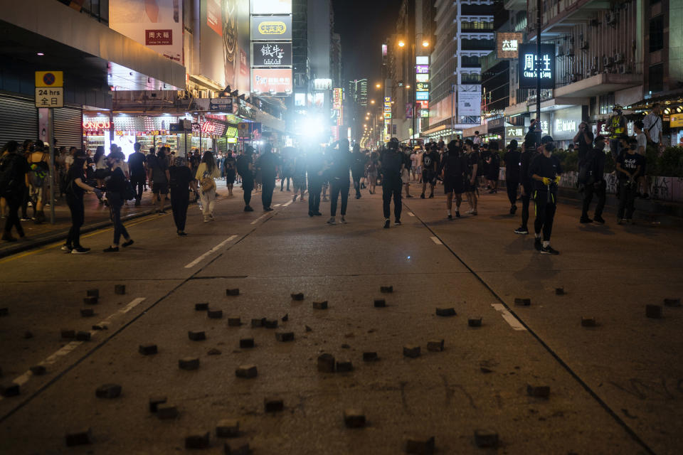 Riot police chase protesters near a demonstration in Hong Kong, Monday, Oct. 7, 2019. Tens of thousands of masked protesters marched defiantly in the city center Sunday, but the peaceful rallies quickly degenerated into chaos at several locations as hard-liners again lobbed gasoline bombs, started fires and trashed subway stations and China-linked banks and shops.(AP Photo/Felipe Dana)