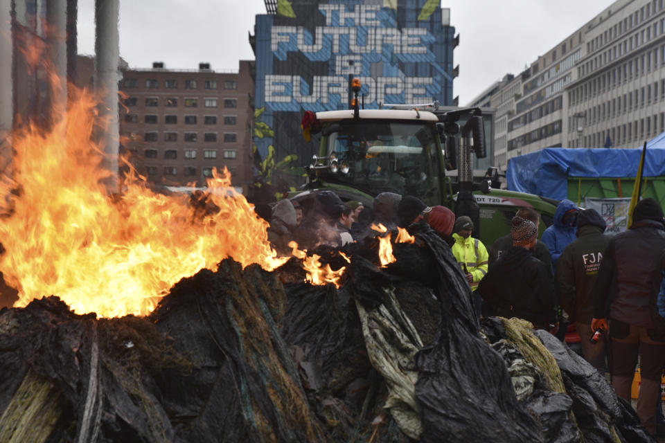 FILE - Protestors light fires during a farmers demonstration in the European Quarter outside a meeting of EU agriculture ministers in Brussels, on Feb. 26, 2024. It seemed like a throwaway line by European Commission President Ursula von der Leyen, yet it encapsulated what is at stake for many in this week's European Union parliamentary elections — What to do with the hard right? And should it be trusted? (AP Photo/Harry Nakos)