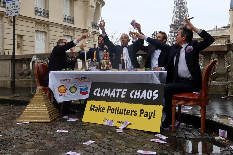 FILE PHOTO: Climate activists denounce fossil fuel companies near the Eiffel Tower in Paris