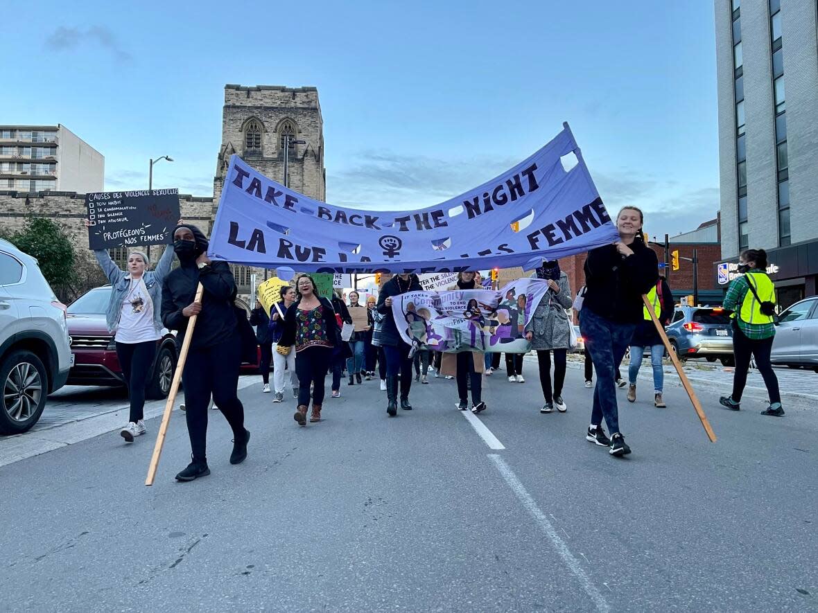 Dozens of people took to the streets Thursday night to call for an end to gender-based violence. (Rachelle Elsiufi/ CBC - image credit)