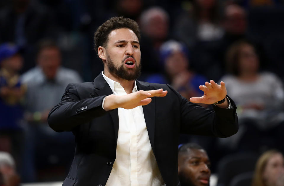 Injured Klay Thompson #11 of the Golden State Warriors reacts on the bench after the Warriors made a basket against the Oklahoma City Thunder at Chase Center.