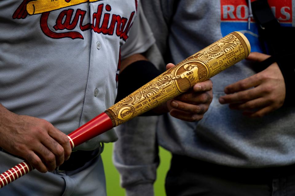 St. Louis Cardinals first baseman Albert Pujols (5) holds a commemorative bat given to him by the Cincinnati Reds owning his years of baseball ahead of his presumed retirement before the MLB game between between the Cincinnati Reds and the St. Louis Cardinals at Great American Ball Park in Cincinnati, Wednesday, Aug. 31, 2022.