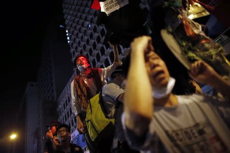 Pro-democracy protesters stand by a barricade as they prepare for a confrontation with riot police at the Mongkok shopping district of Hong Kong October 20, 2014. REUTERS/Carlos Barria