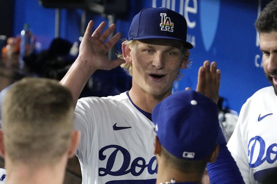 Dodgers pitcher Emmet Sheehan celebrates with Mookie Betts in the dugout.