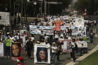 People carry photographs during a march in remembrance of those who have disappeared, on Mother's Day in Mexico City, Monday, May 10, 2021. (AP Photo/Fernando Llano)