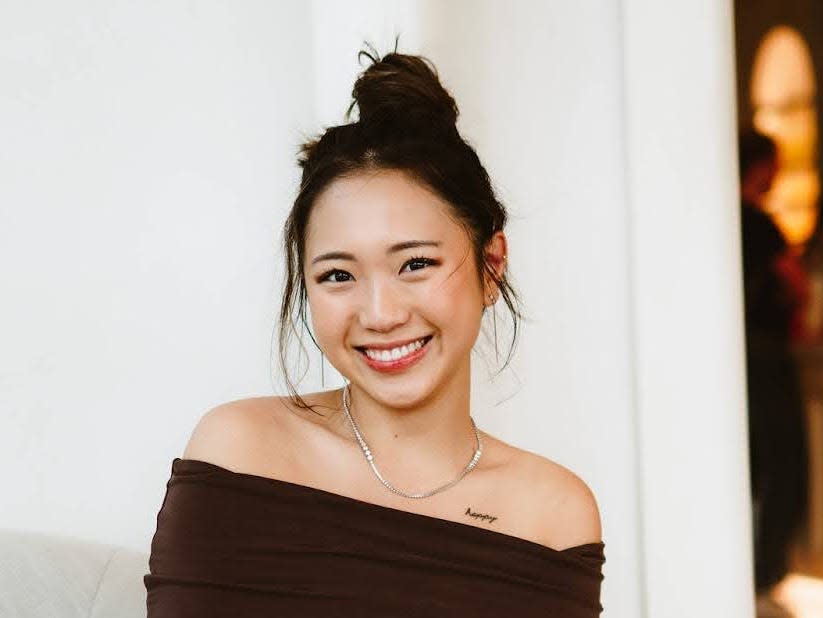 a girl in a brown shirt sitting on a chair