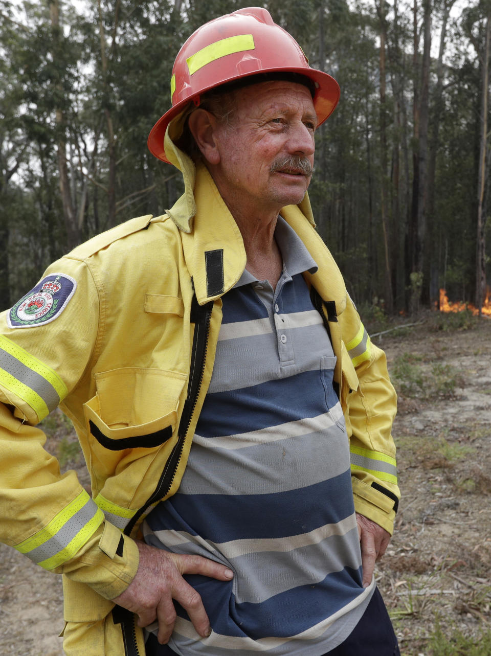 Doug Schutz, the Tomerong Rural Fire Service Captain, oversees a controlled burn near Tomerong, Australia, Wednesday, Jan. 8, 2020, set in an effort to contain a larger fire nearby. Schutz began volunteering with the Rural Fire Service in New South Wales some 53 years ago, at the age of 13. That was back in the days when the fire truck was a Land Rover that towed a trailer with a water pump on top. Schutz is part of an army of 72,000 people from across the state who make up the world's largest volunteer fire service. (AP Photo/Rick Rycroft)