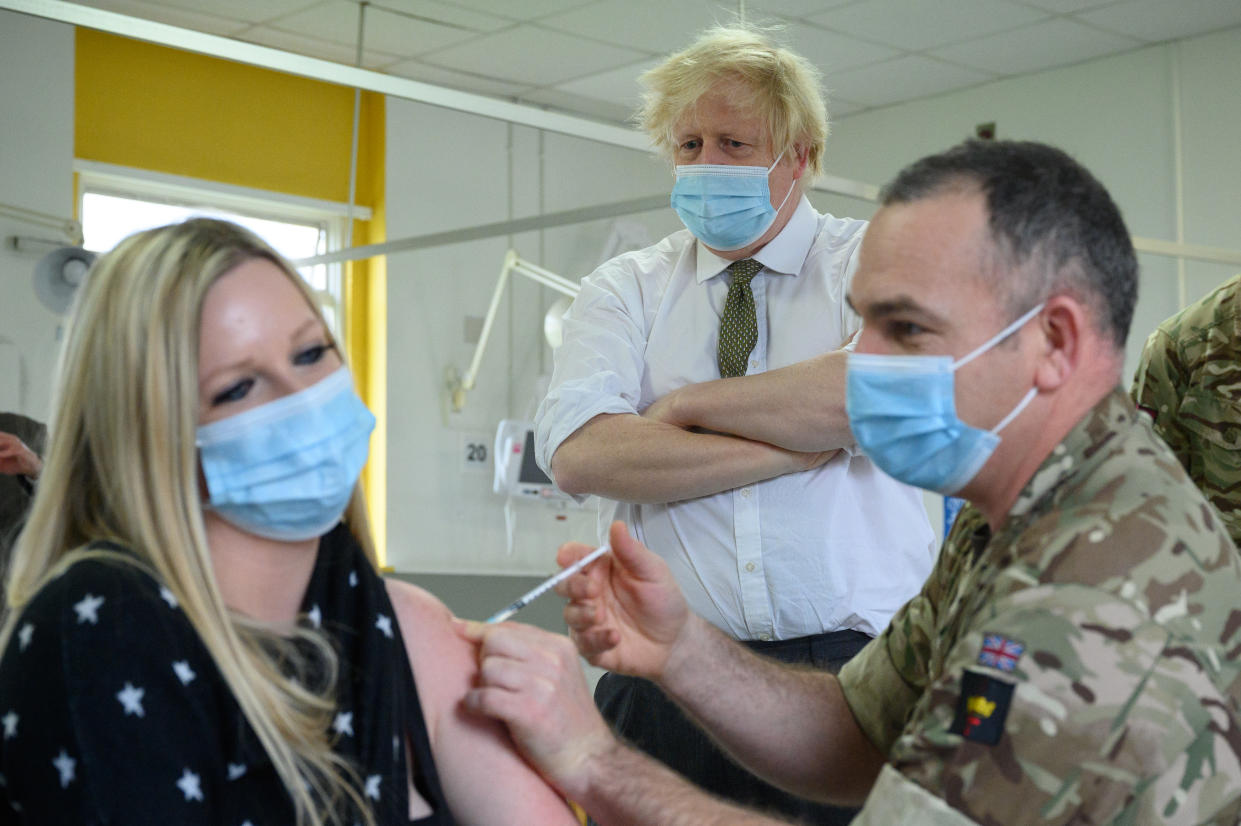 UXBRIDGE, ENGLAND - DECEMBER 17: Britain's Prime Minster Boris Johnson (C) looks on as a woman receives a Covid-19 booster jab, during a constituency visit to a vaccination centre at Hillingdon Hospital on December 17, 2021 in Uxbridge, England. (Photo by Leon Neal/Getty Images)