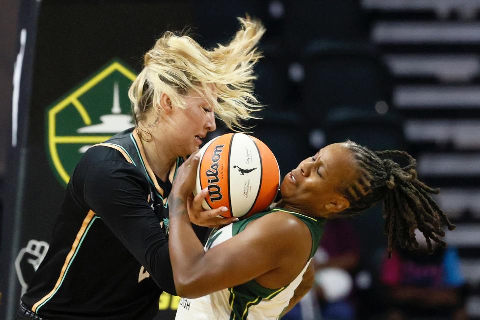 Kylee Shook and Epiphanny Prince battle for a ball during a WNBA game between the New York Liberty and Seattle Storm.