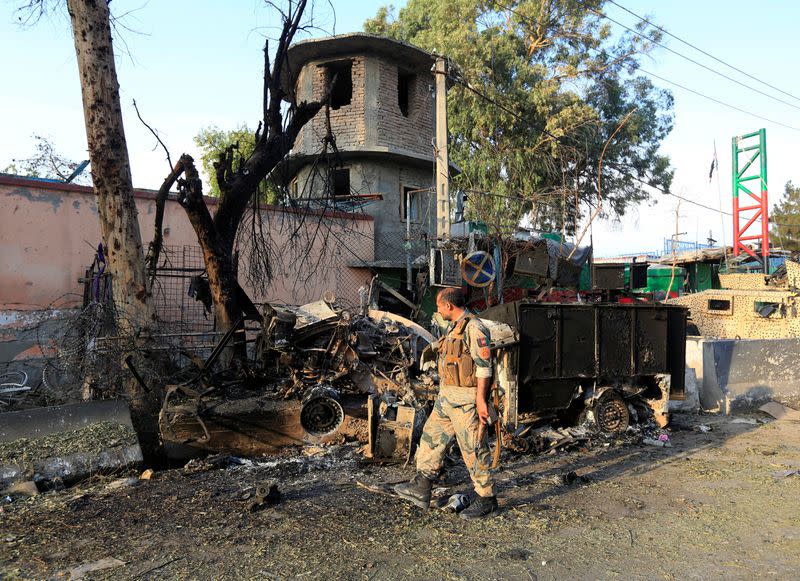 A member of Afghan security forces inspects the site of an attack on a jail compound in Jalalabad