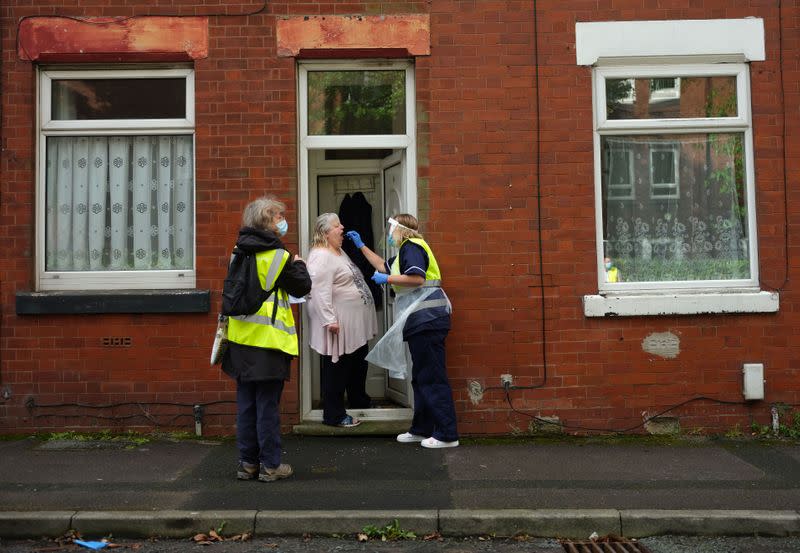 A member of the community swabbing team carries out a doorstep COVID-19 test following the outbreak of the coronavirus disease (COVID-19) in Chadderton, Britain