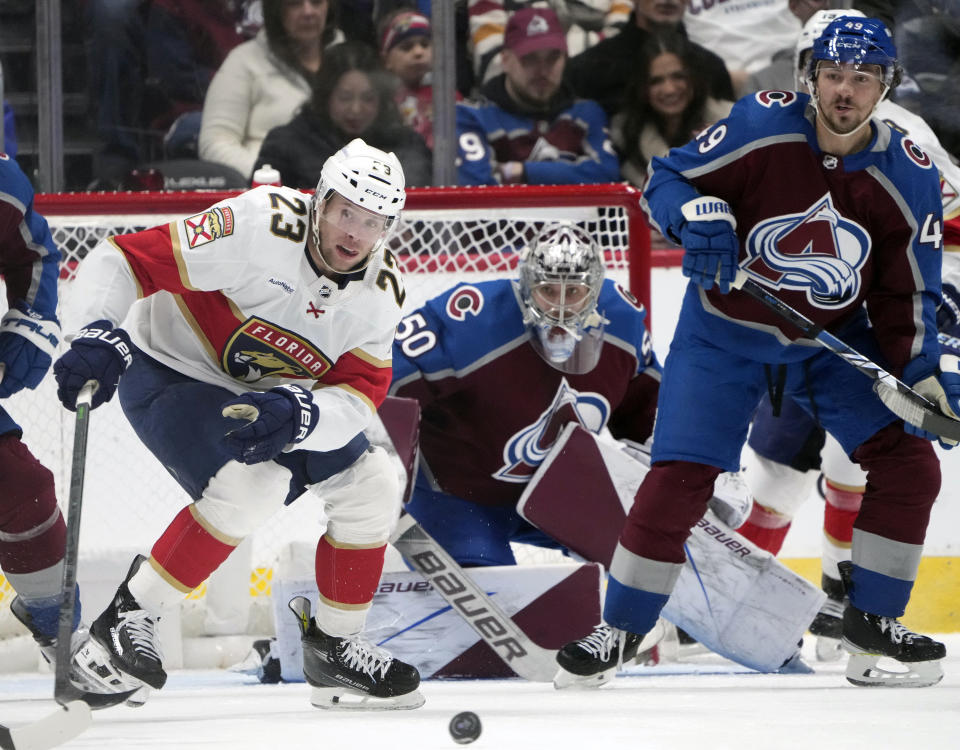 Florida Panthers center Carter Verhaeghe (23) looks for the puck as Colorado Avalanche defenseman Samuel Girard, right, and goaltender Ivan Prosvetov (50) protect the net in the first period of an NHL hockey game Saturday, Jan. 6, 2024, in Denver. (AP Photo/David Zalubowski)