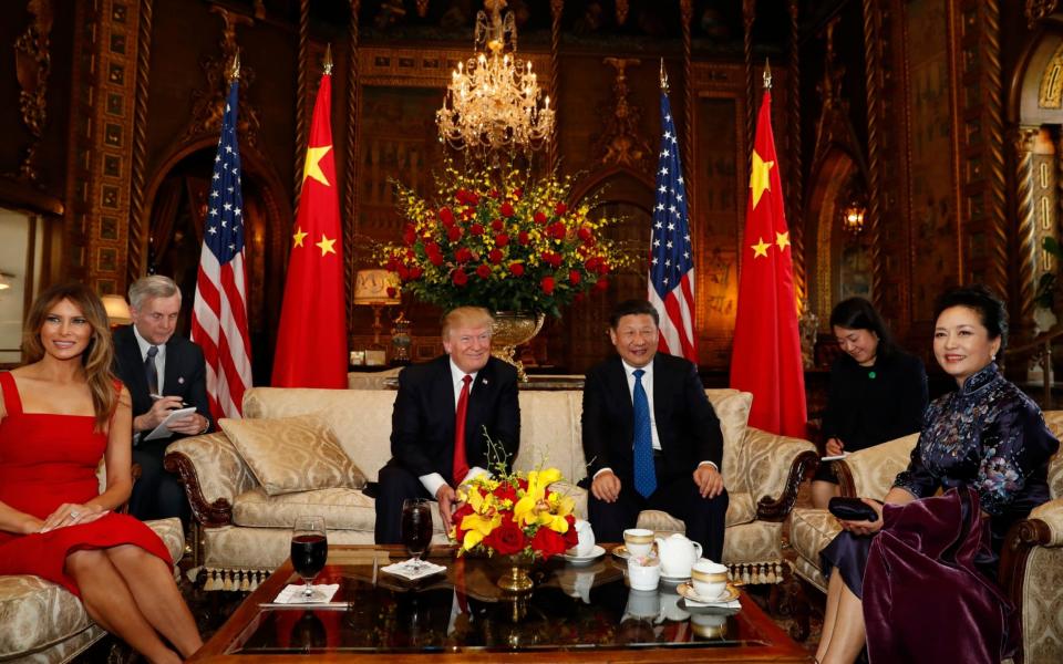 President Donald Trump and Chinese President Xi Jinping, with they wives, first lady Melania Trump, left, and Chinese first lady Peng Liyuan, right, pose for photographers before dinner at Mar-a-Lago, Thursday, April 6, 2017, in Palm Beach, Fla - Credit: Alex Brandon/AP