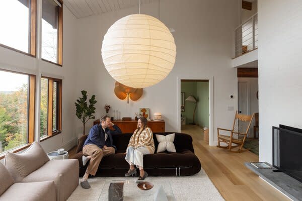 The living room features a Noguchi lantern, a velvet Soriana sofa by Afra and Tobia Scarpa, Ingo Maurer Uchiwa 6 fan lights, and a teak Hans Wegner credenza.