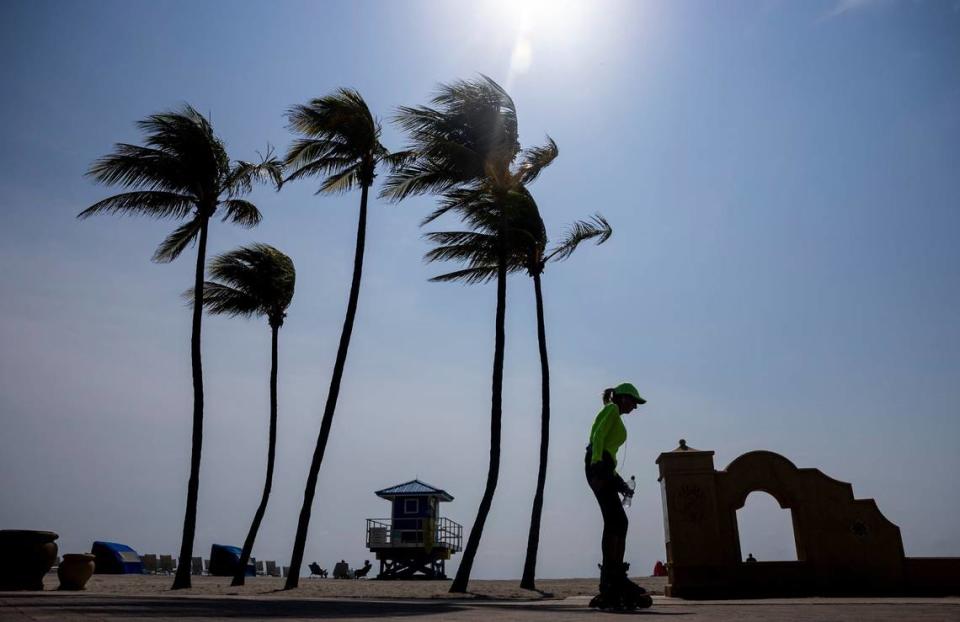 A woman makes her way along the Hollywood Beach Broadwalk as temperatures climb into the 90s on Tuesday, May 14, 2024 in Hollywood, Florida.