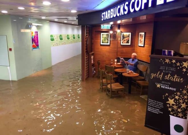 This man chilling in a Starbucks during a flood is all of us