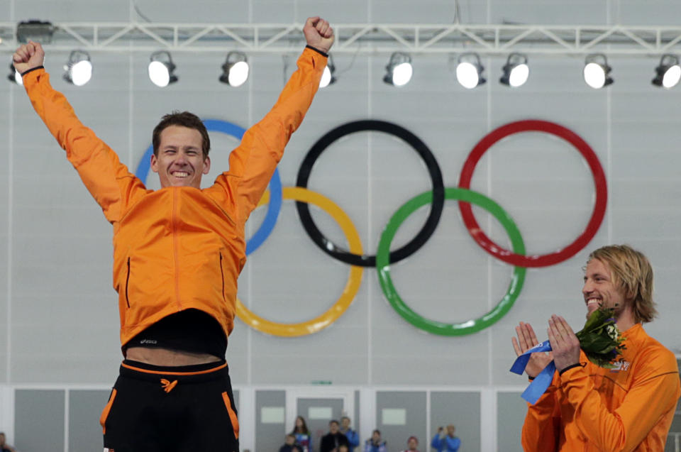 Bronze medallist Michel Mulder from the Netherlands, right, applauds country skater and gold medallist Stefan Groothuis during the flower ceremony for the men's 1000-meter speedskating race at the Adler Arena Skating Center during the 2014 Winter Olympics in Sochi, Russia, Wednesday, Feb. 12, 2014. (AP Photo/Matt Dunham)