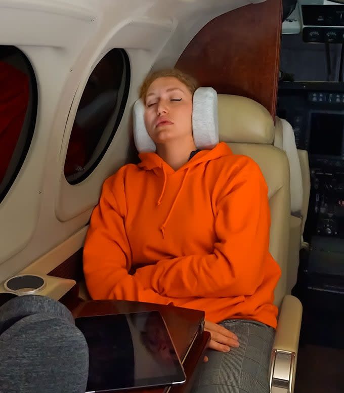 Young woman uses her SleepMuffs to get some much-needed rest on a long flight.
