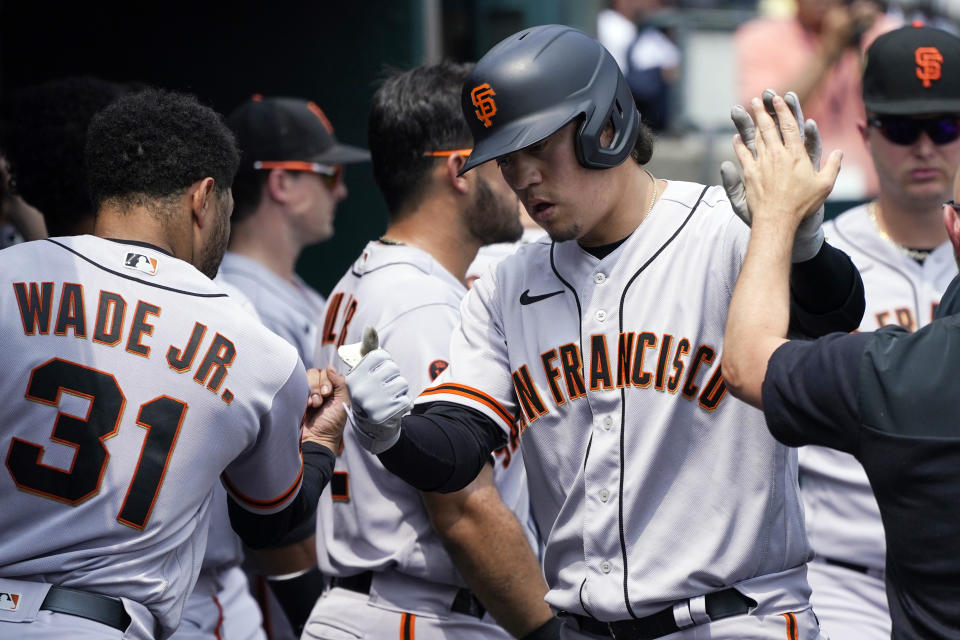 San Francisco Giants designated hitter Wilmer Flores is greeted in the dugout after his solo home run during the sixth inning of a baseball game against the Detroit Tigers, Monday, July 24, 2023, in Detroit. (AP Photo/Carlos Osorio)