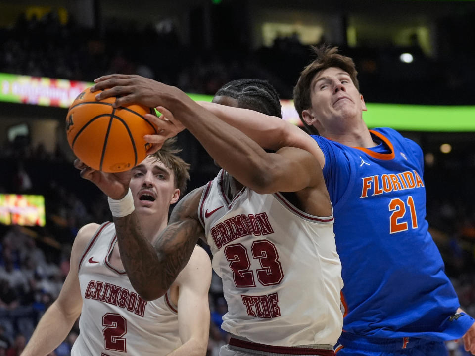 Alabama forward Nick Pringle (23) and Florida forward Alex Condon (21) vie for a rebound during the first half of an NCAA college basketball game at the Southeastern Conference tournament Friday, March 15, 2024, in Nashville, Tenn. (AP Photo/John Bazemore)