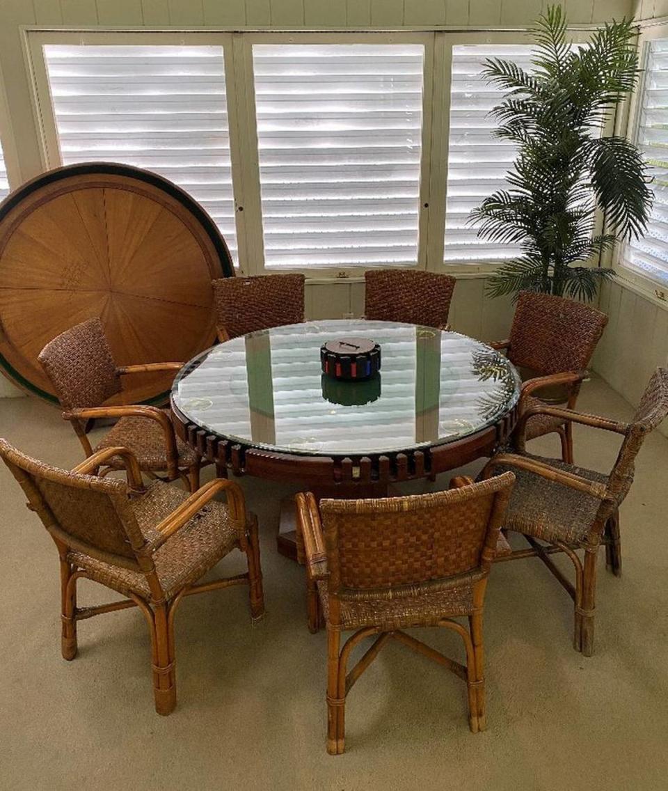 The poker table at The Little White House in Key West, made of four layers of solid Key West mahogany, has built-in chip holders, recycled 3-inch brass shell casings for the ashtrays and a cover — seen in the background — for concealing there was ever a game in the house.