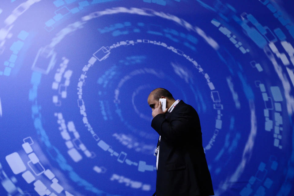 A man walks with his phone at the Mobile World Congress.