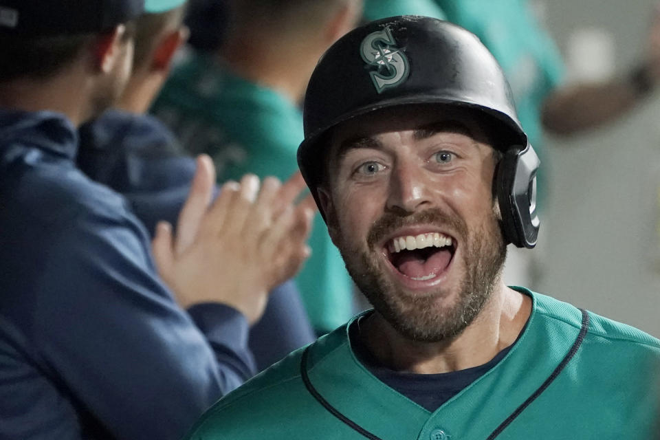 Seattle Mariners' Tom Murphy reacts in the dugout after hitting a two-run home run to also score Luis Torrens during the second inning of a baseball game against the Arizona Diamondbacks, Friday, Sept. 10, 2021, in Seattle. (AP Photo/Ted S. Warren)